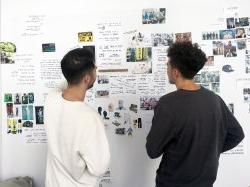产品设计专业的学生在墙上讨论项目