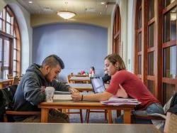 两个学生在大学大厅学习.