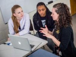 三个女人围着电脑讨论着什么
