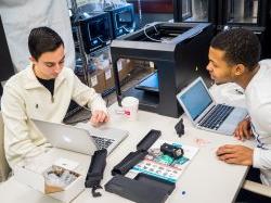 两名学生在MIX实验室的笔记本电脑前