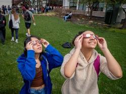物理学专业的Mariana Pereira和Jasmine Valencerina戴着日食眼镜看起来很酷. [摄影:John LaRosa.]