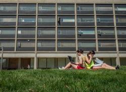 两个学生坐在布兰顿大厅外的草坪上