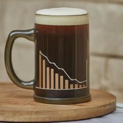 A mug of dark beer with foam on top with a line graph on the mug.